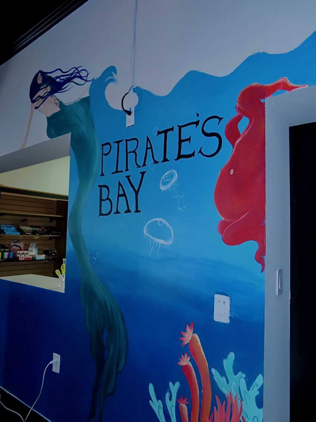 Hand-painted Pirate's Bay mermaid and octopus mural inside the store