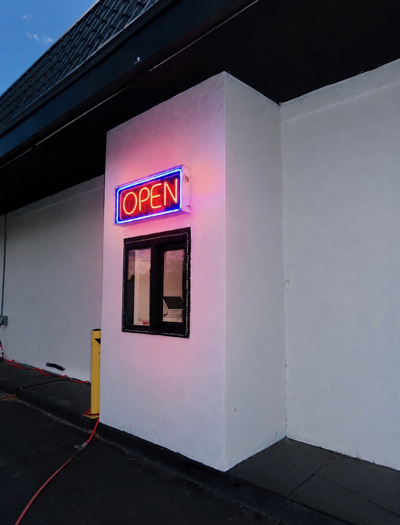 Neon OPEN sign at the Pirates Bay drive-thru window